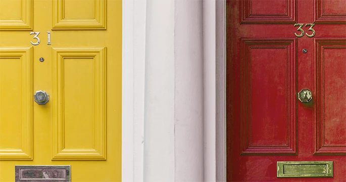 Zwei nebeneinanderliegende Türen in Gelb und Rot als Metapher für die differenzierte Adressprüfung durch SanScreen der OdiSys GmbH.